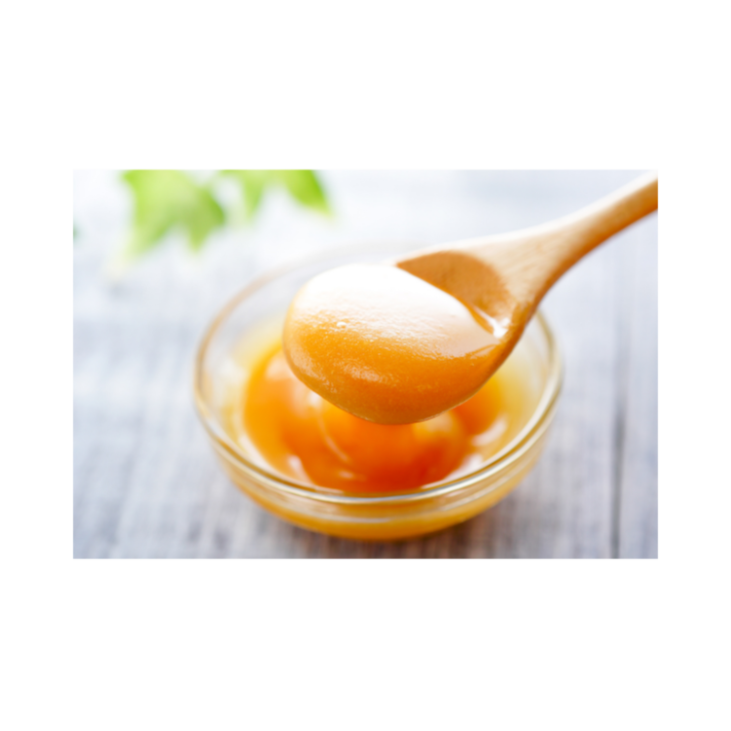 Spoonful of manuka honey substance in a glass bowl on a white background