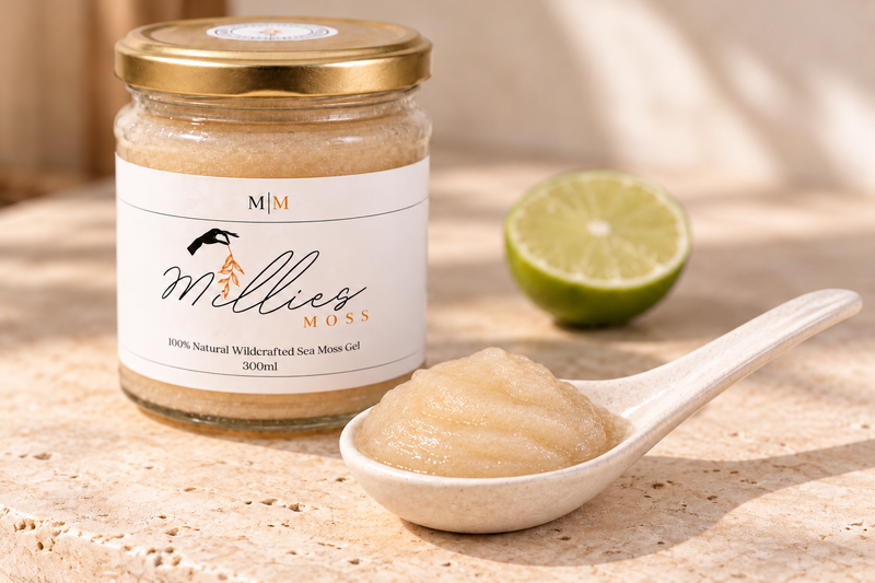 Golden sea moss gel on a ceramic spoon beside a Millie’s Moss jar and half a lime.
