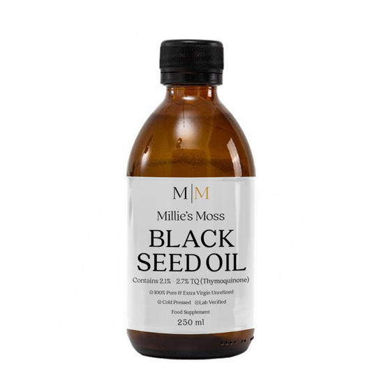 A 250ml bottle of Millie's Moss Black Seed Oil with a black cap and a label that includes the product name and the contained thymoquinone percentage. Pure Virgin unrefined and cold pressed