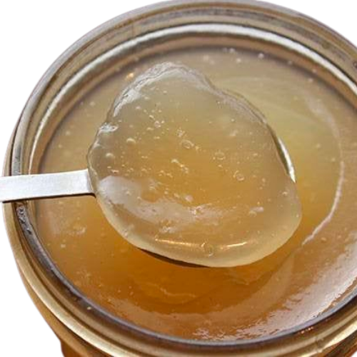 Spoon lifting a scoop of manuka sea moss gel from a jar