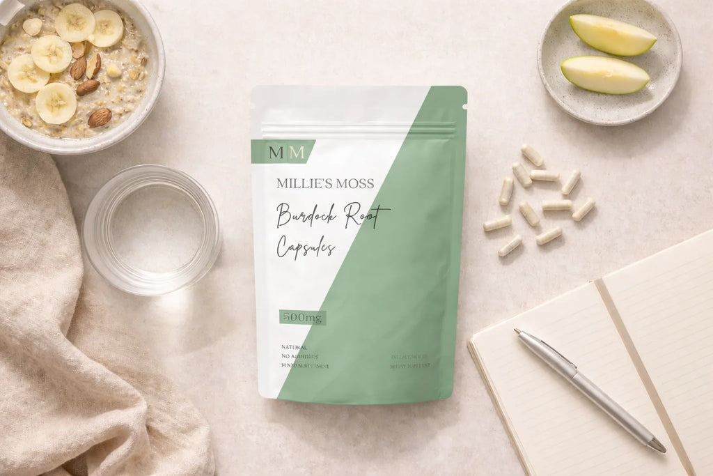 Flat lay of burdock root capsules with breakfast bowl, apple slices, and notebook for a daily wellness routine.
