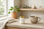 Jar of sea moss gel on a kitchen counter beside a cup of tea in a calm morning setting