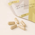 Close-up of Millie’s Moss Golden Sea Moss Capsules showing golden capsules in front of the product pouch.