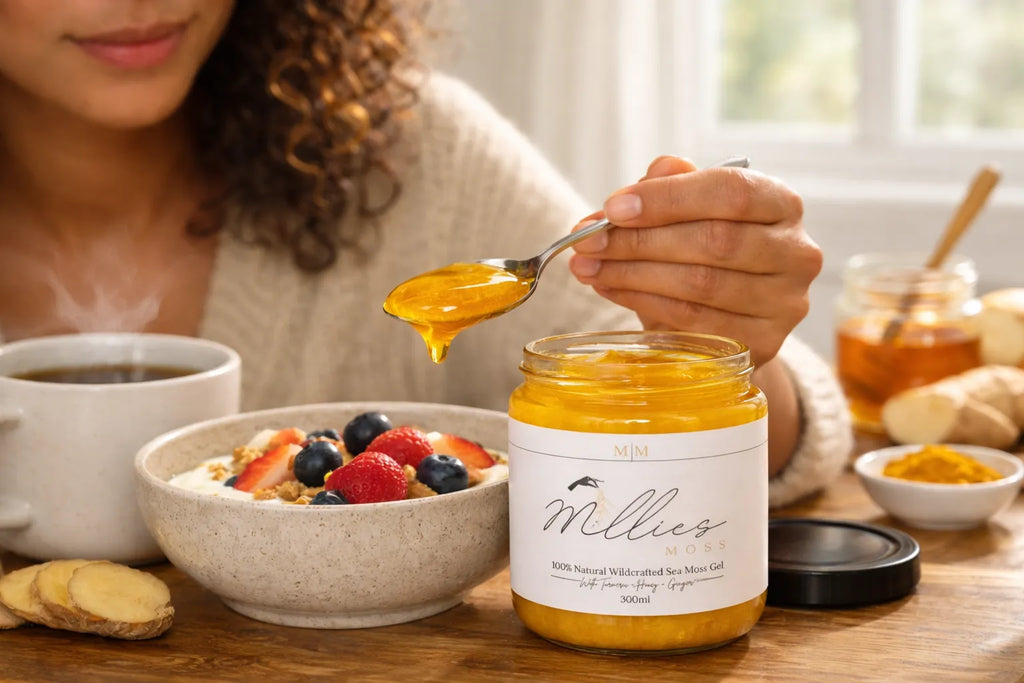 Sea moss gel with turmeric, honey and ginger being added to a healthy breakfast bowl with berries and yogurt