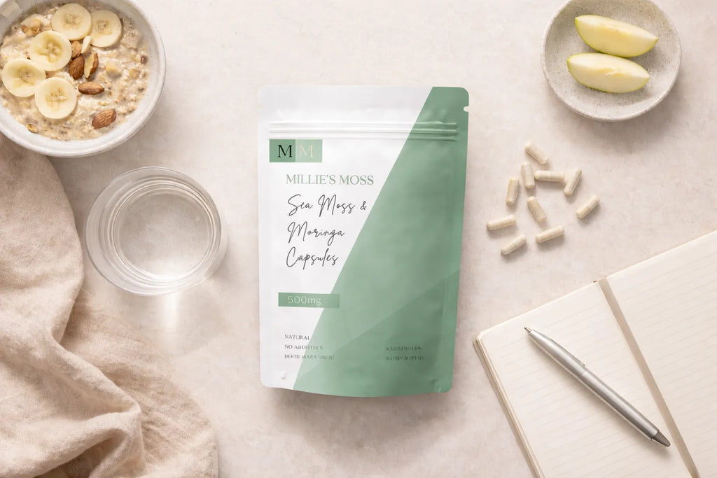 Flat lay of sea moss and moringa capsules with breakfast bowl, apple slices, and notebook for a daily wellness routine.